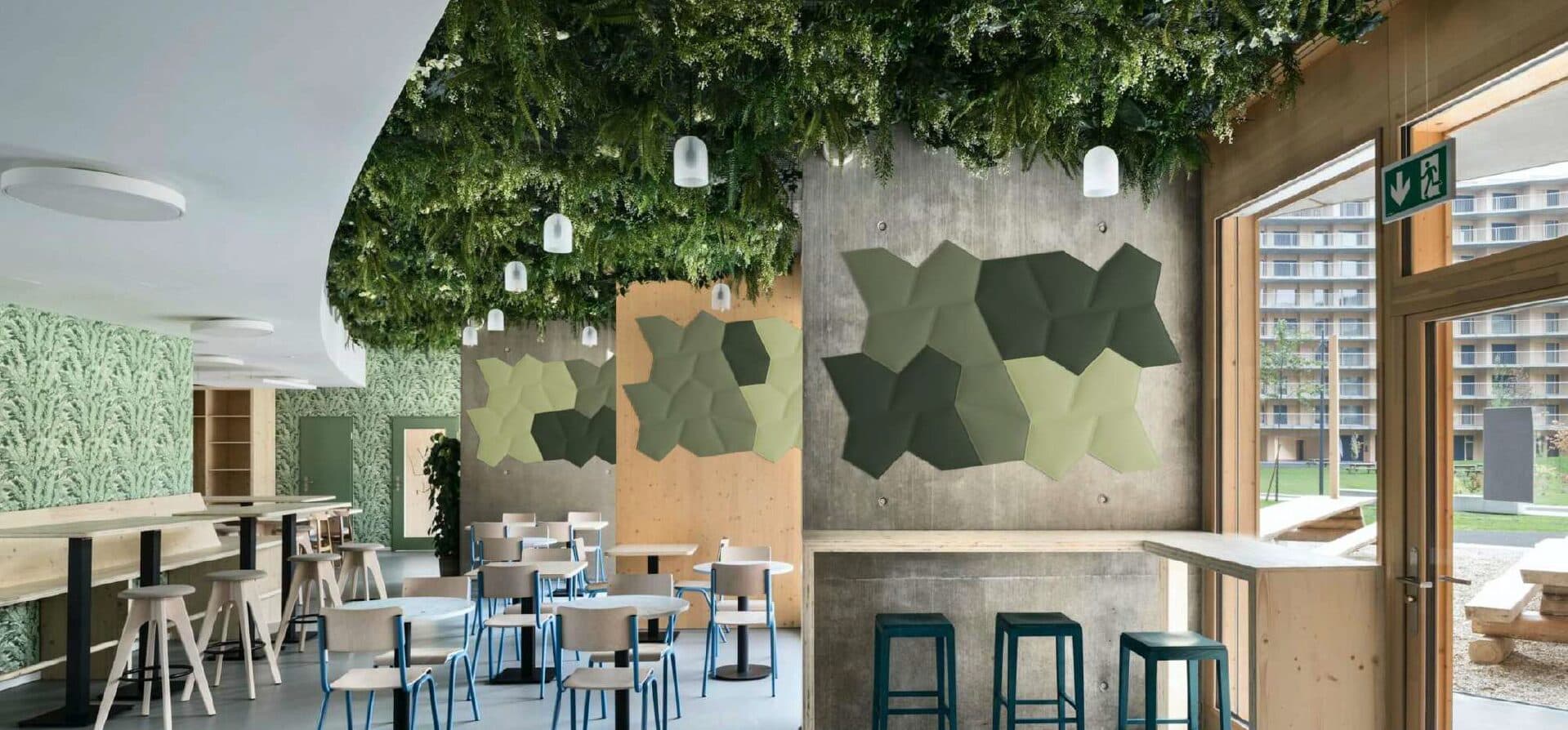 Campus café with sculpted green acoustic wall tiles and planting overhead